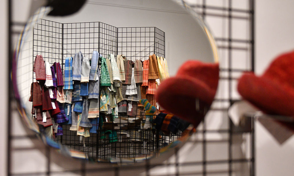 Scarves are reflected in a mirror during setup for the 30th Annual Columbia Weavers